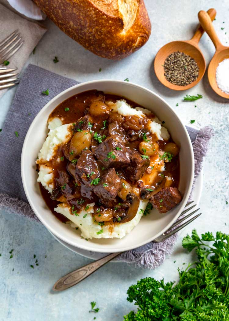 overhead: bowl of homemade french beef stew served over mashed potatoes