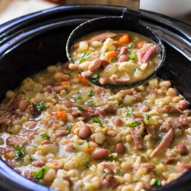 There's nothing like a Slow Cooker Ham Bone Bean Soup simmering away. Smoked ham bone with beans and barley, vegetables and Tabasco for that special touch. This really feeds a crowd! www.keviniscooking.com