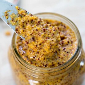 A clear glass jar with Mustard