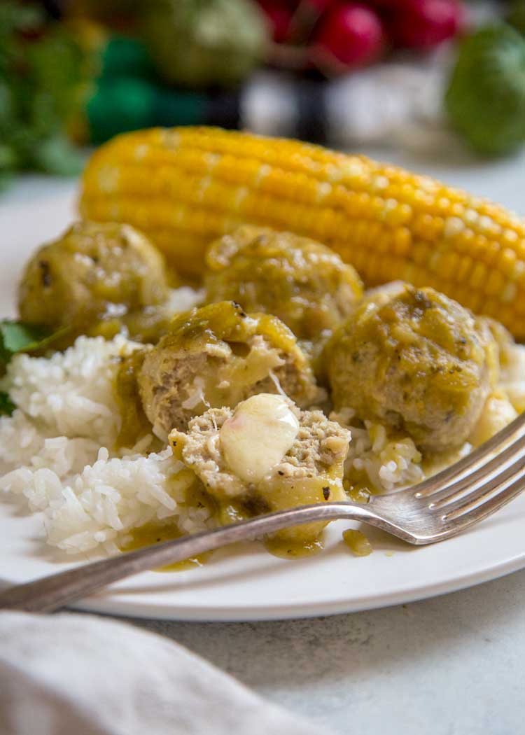 cheese stuffed meatballs on white plate with rice and corn