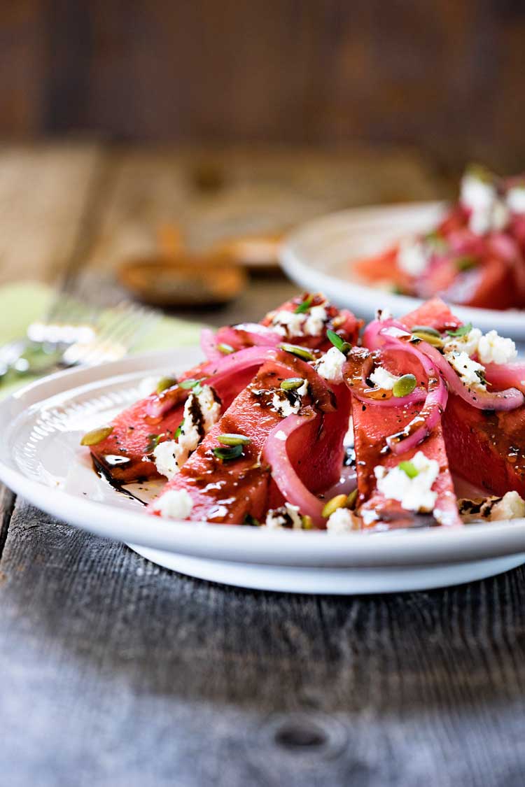 This Watermelon Salad has arugula, pickled red onions, creamy goat cheese, balsamic syrup and roasted pumpkin seeds. It's a perfect starter or side salad. www.keviniscooking.com