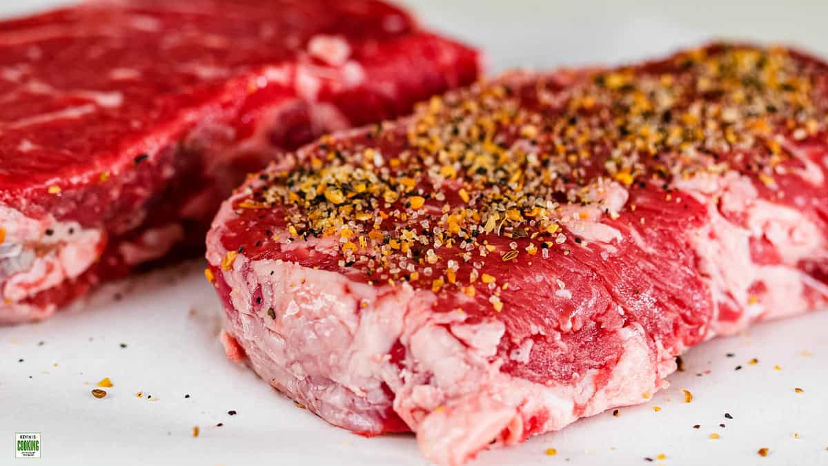 raw steaks with dry rub seasoning on them