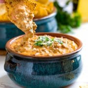 close up: dipping chip into beef queso dip