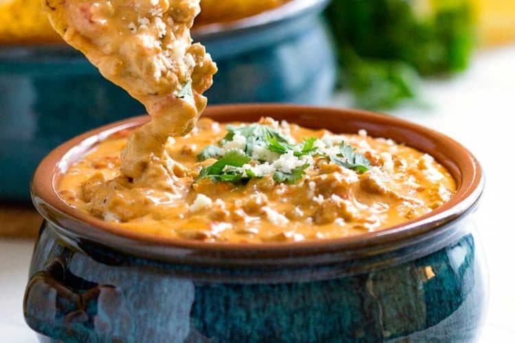 close up: dipping chip into beef queso dip