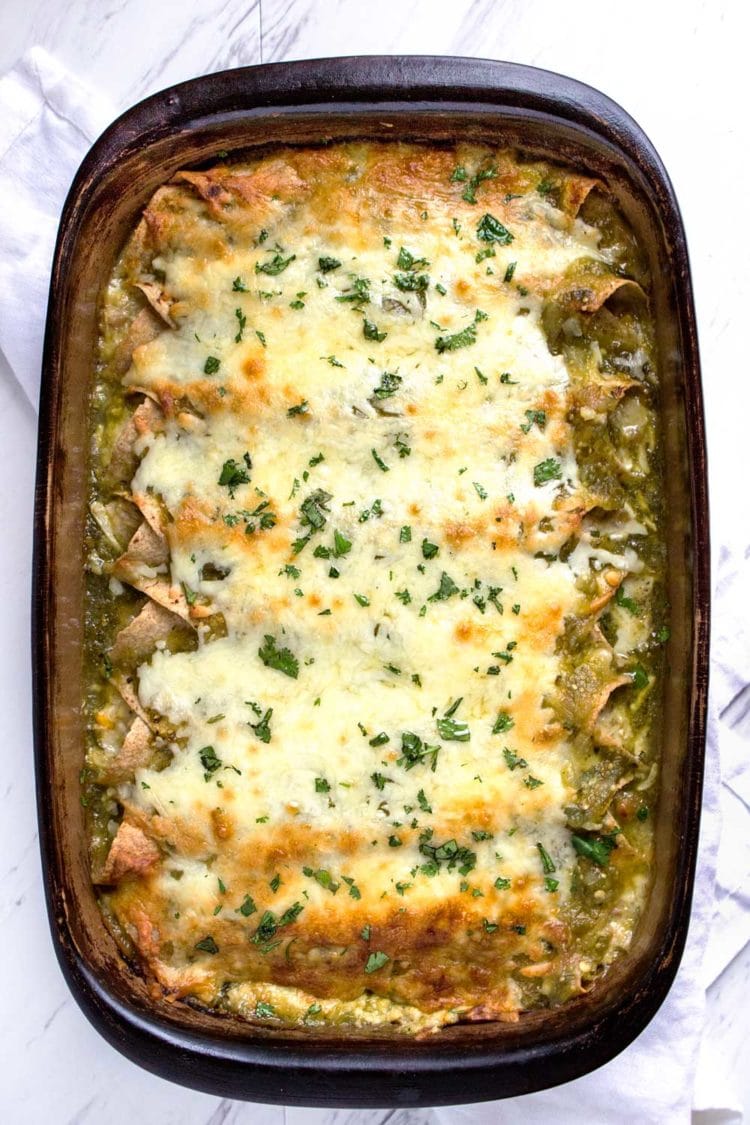 overhead: pan of enchiladas verdes de pollo covered with melted white cheese