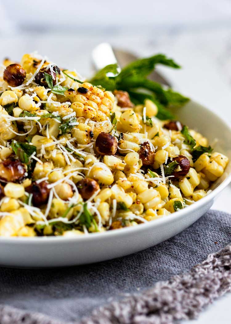 grilled corn salad with hazelnuts in a white bowl
