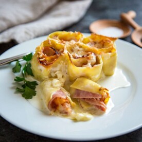 Ham and Cheese Pasta Rosettes start with fresh pasta sheets, sliced ham, fontina or provolone cheese. Roll up, cover with with cream and nutmeg and bake! keviniscooking.com
