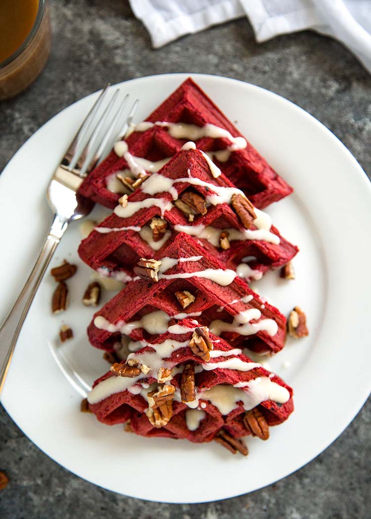 Red Velvet Waffles with Cream Cheese Glaze on white plate.