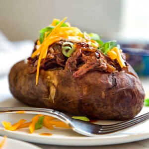 These Slow Cooker BBQ Beef Stuffed Potatoes are a perfect one pot meal made in the slow cooker. A wet rubbed chuck roast with BBQ sauce and the potatoes! keviniscooking.com