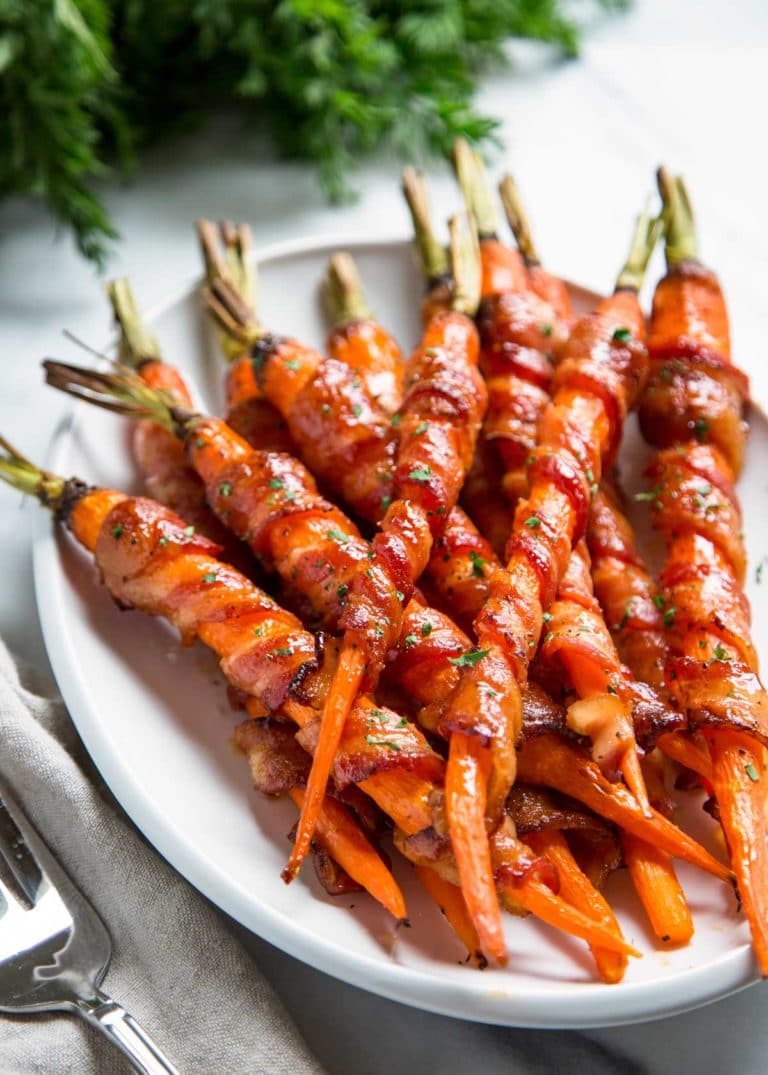 These Bacon Wrapped Carrots get sprinkled with black pepper and roasted, then basted with a maple Sriracha sauce until crispy. So easy and good! keviniscooking.com
