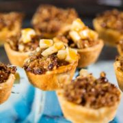 These Mini Peanut Butter Apple Pies have it all. Flakey pastry, peanut butter, diced apples, cinnamon and are topped with a crumb topping and caramel. keviniscooking.com