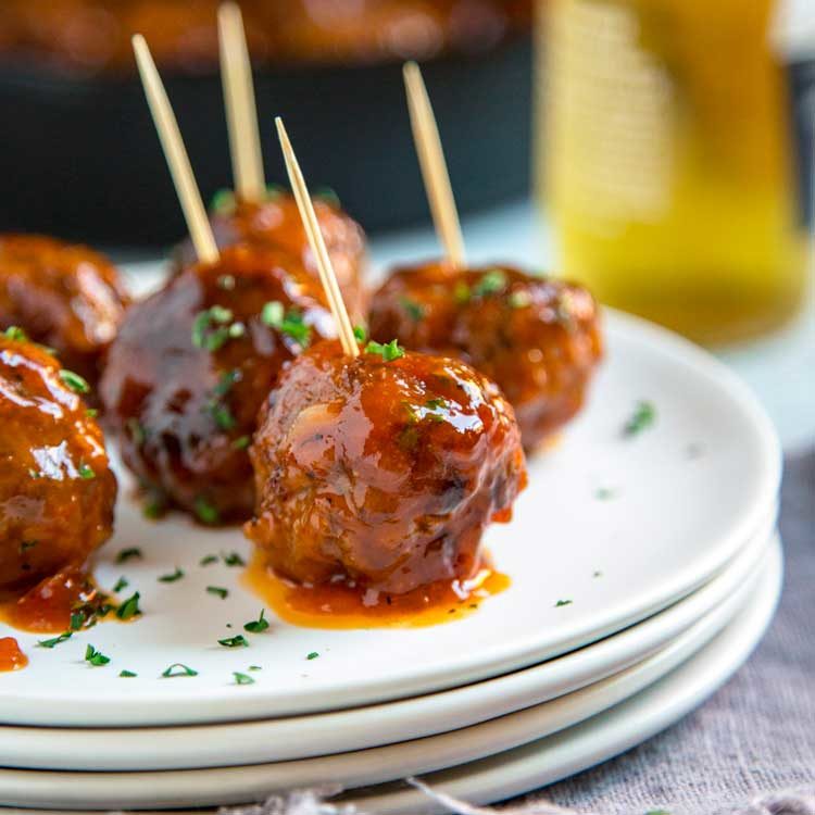 A close up of Apricot chipotle meatballs on a plate, with Sauce