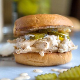 close up of a shredded chicken sandwich with pickles