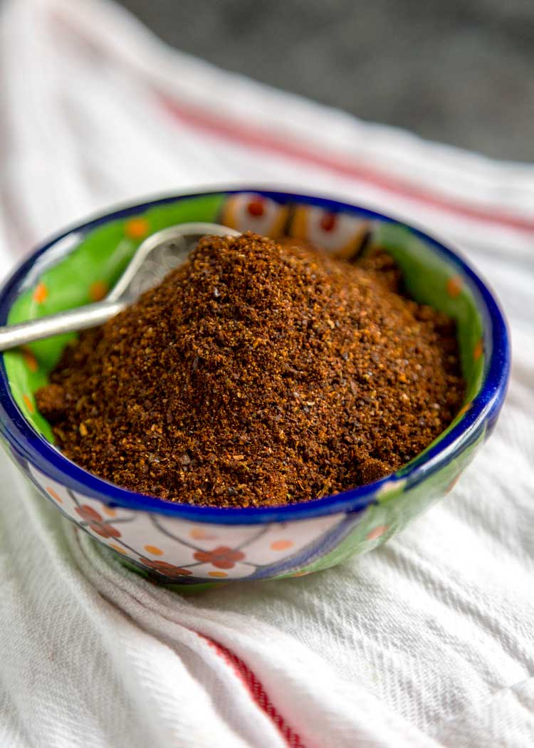 closeup: Mexican chilli powder in small bowl with colorful blue and green design/pattern
