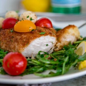 This easy to make Chicken Milanese starts with butterflied chicken breasts that are lightly breaded and pan fried to a golden brown. I plate on a bed of dressed arugula greens and top with mozzarella and tomatoes for a quick, delicious lunch or dinner.