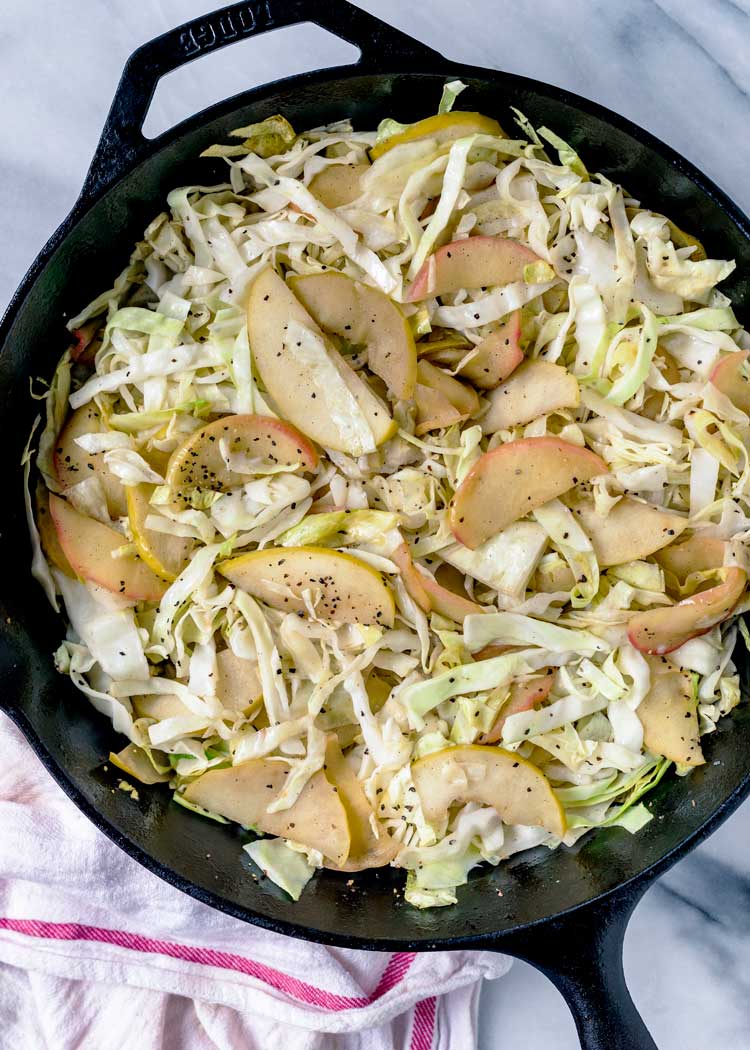 overhead shot of cabbage and apple in cast iron pan