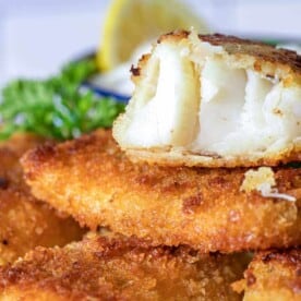 A close up of baked fish sticks with lemon