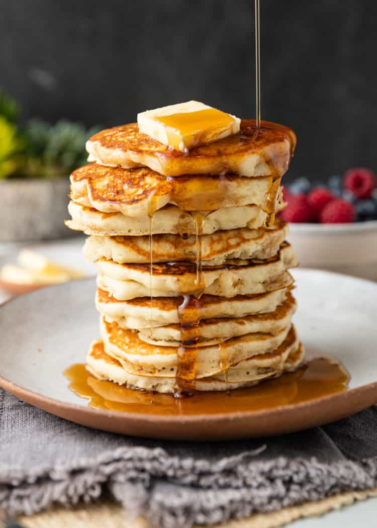 maple syrup poured over top of fluffy pancakes