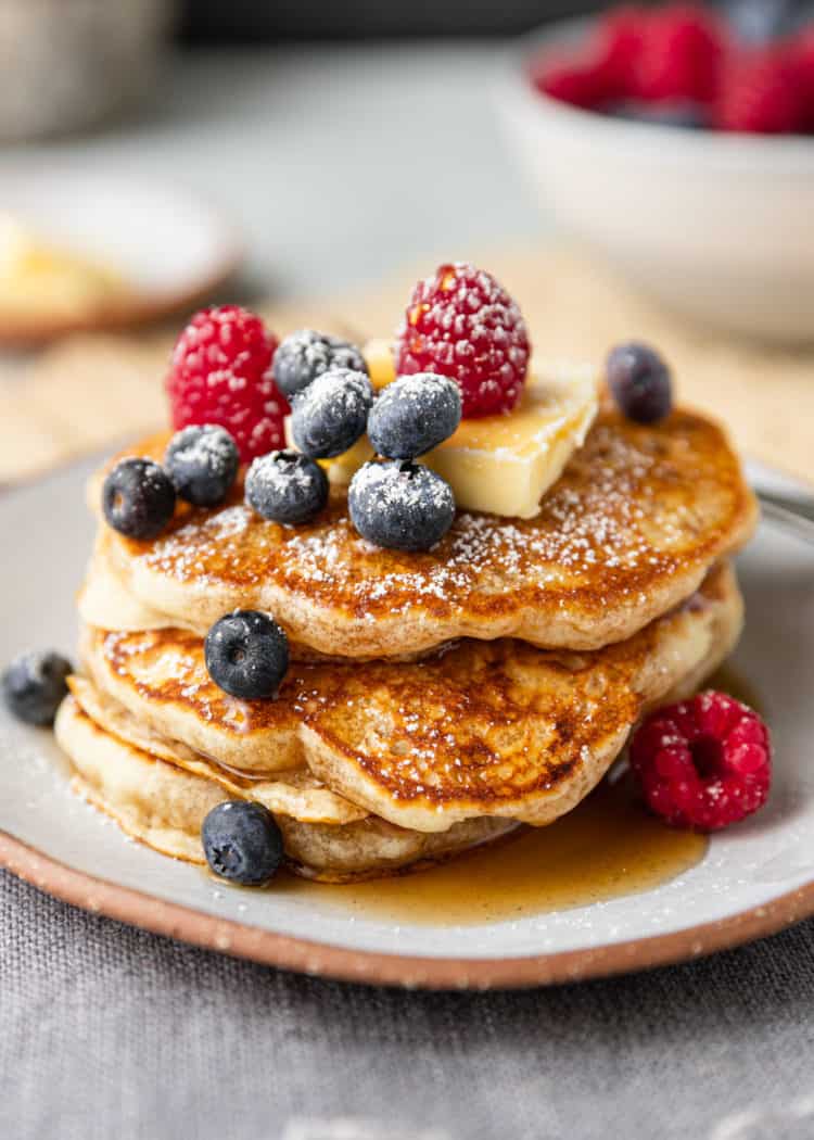 powdered sugar dusted over stack of golden fluffy griddle cakes