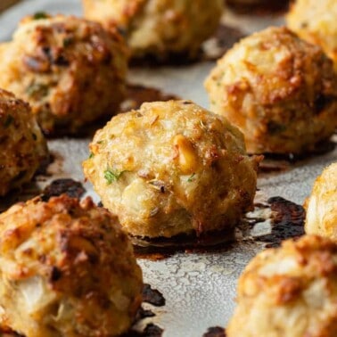 close up of a baked chicken meatballs on sheet pan