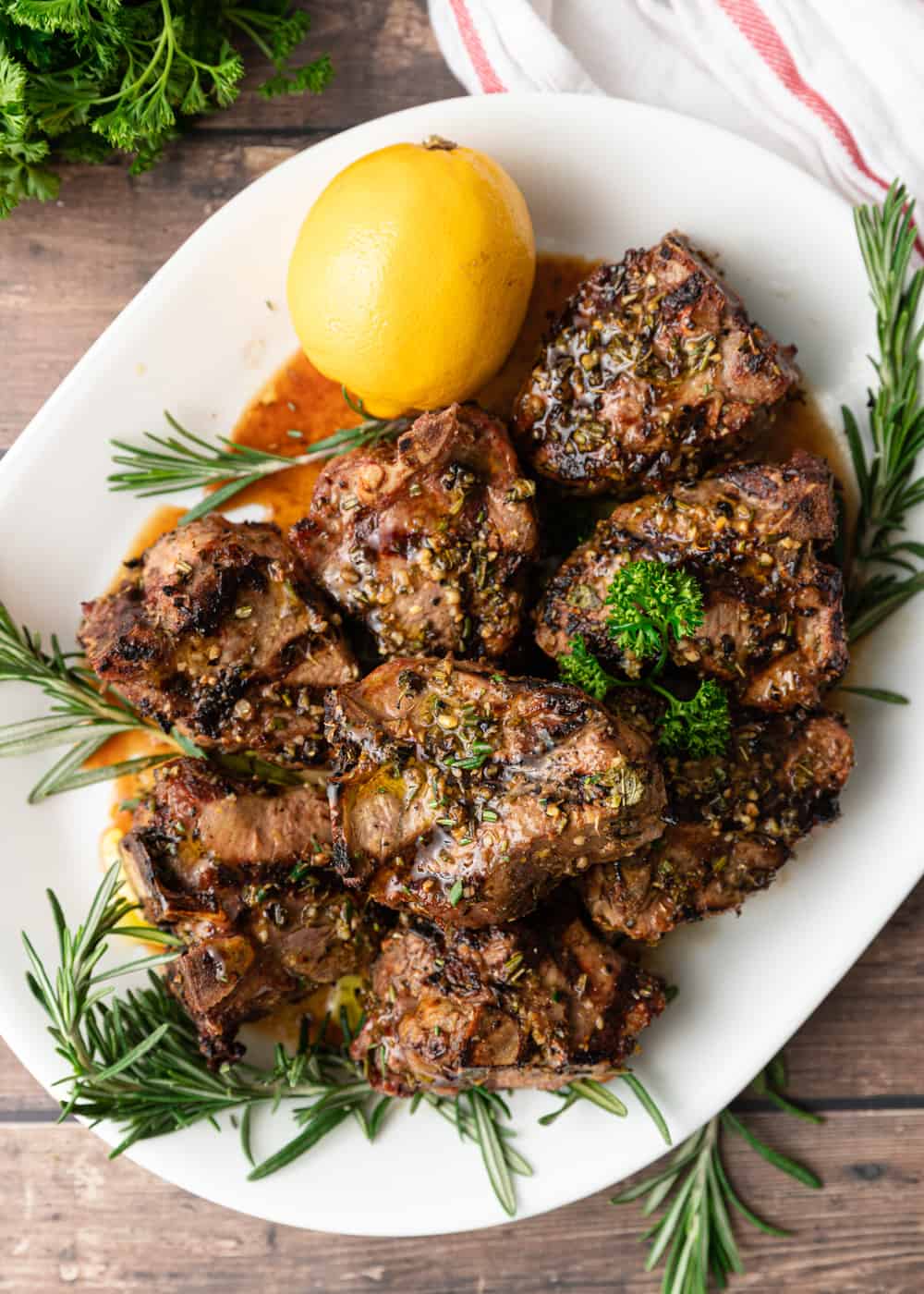 Greek Grilled Lamb Loin Chops on white plate with herbs