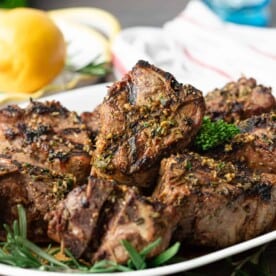A plate of lamb loin chops with herbs and lemon