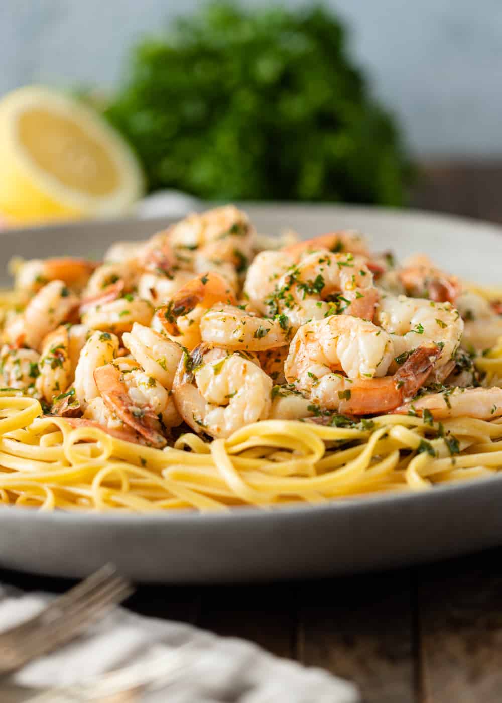 close up photo of garlic butter shrimp on bed of tender pasta