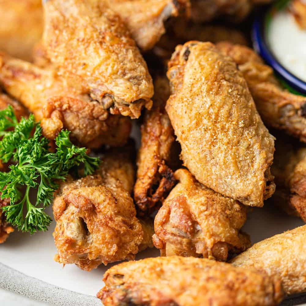 A close up of a plate of crispy baked Chicken wings