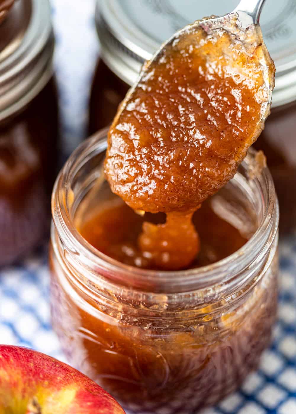 spoonful of creamy homemade apple butter above a jar of it