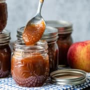 spoonful of homemade apple butter above a jar full