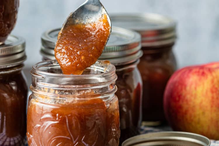 spoonful of homemade apple butter above a jar full