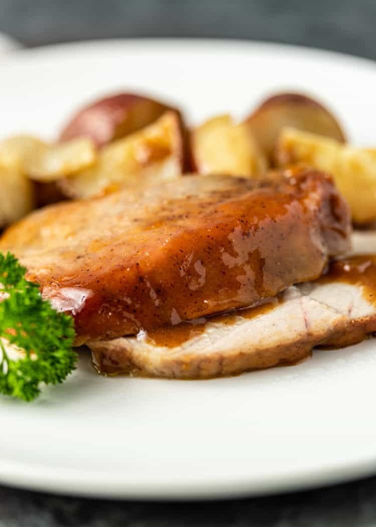 plated serving of glazed pork roast and potatoes
