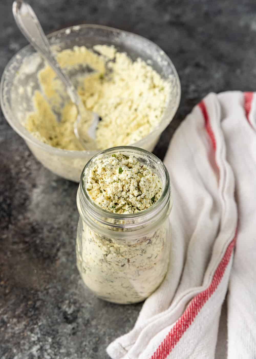 glass jar of powdered Ranch seasoning with bowl and spoon