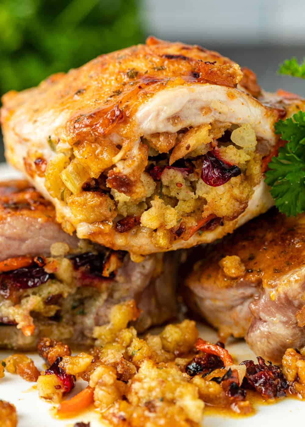 cranberry stuffed baked pork chops stacked on plate