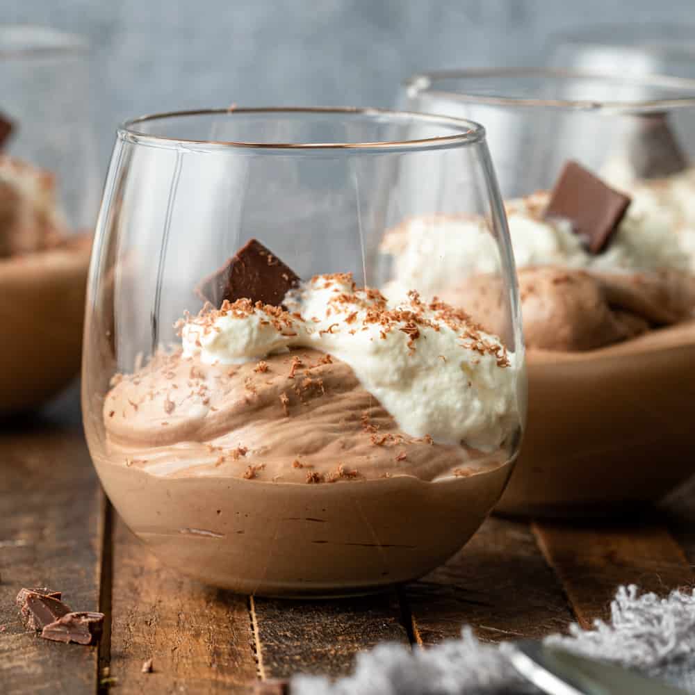 several Chocolate Mousse with whipped cream and shaved chocolate in glass