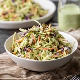 side view: creamy cilantro dressing tossed with shredded green and purple cabbage and carrots