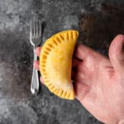 empanada ready for baking in palm of man's hand