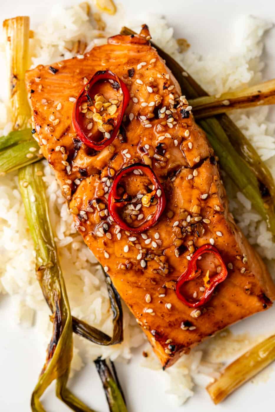 overhead image: glazed fish filet on bed of white rice with charred scallions