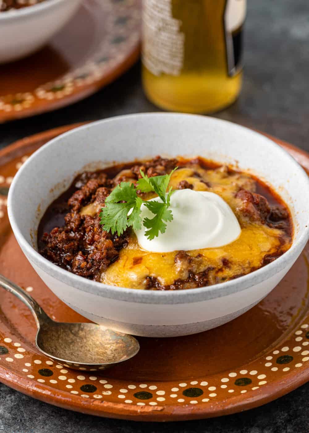 bowl of tex mex ground beef stew topped with melted cheese and sour cream