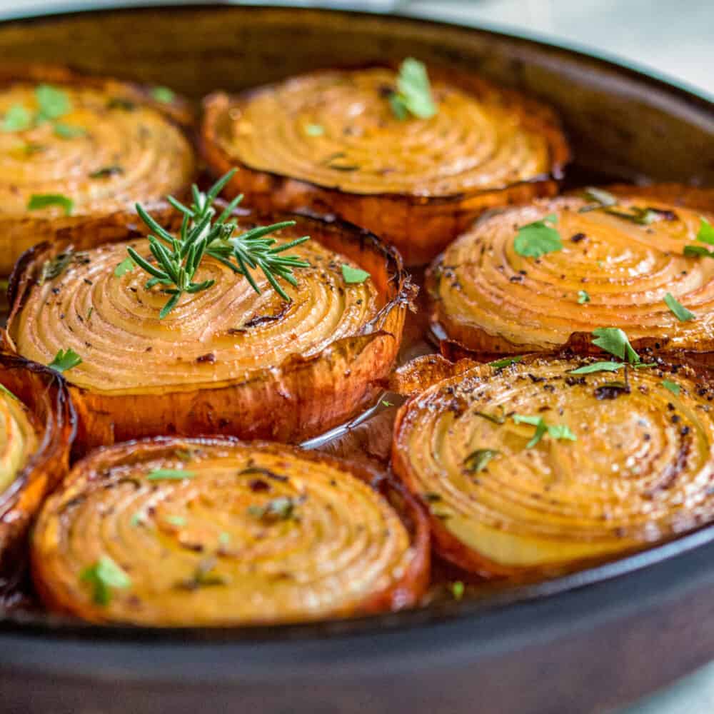 close up of baked onion halves with rosemary