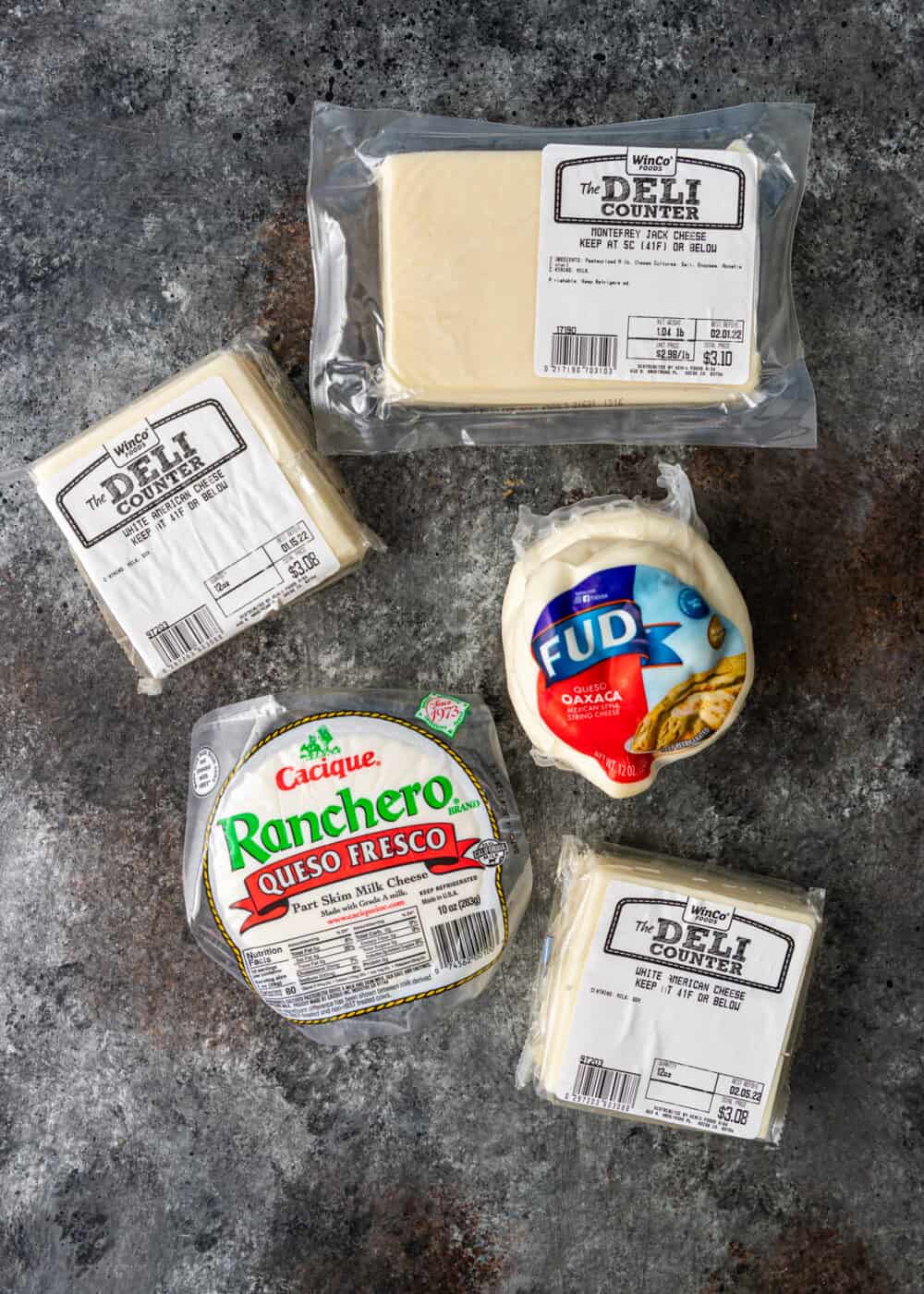 overhead: packages of american white cheese, oaxaca, and queso fresco for queso blanco recipe
