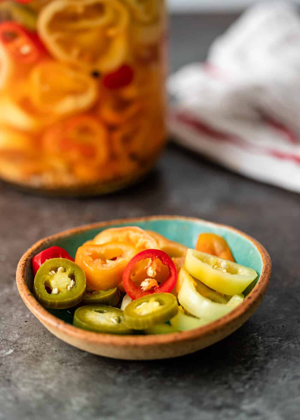 pickled cherry peppers in small bowl with jalapeno slices and banana pepper slices