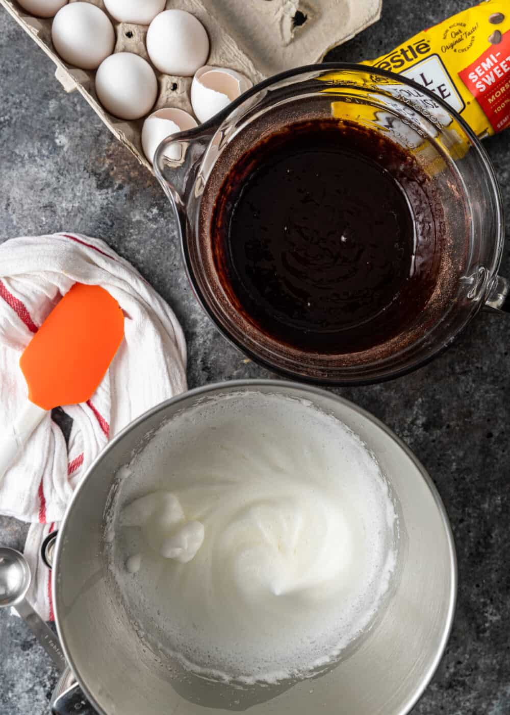 overhead: whipped egg whites in mixing bowl next to mocha cake ingredients