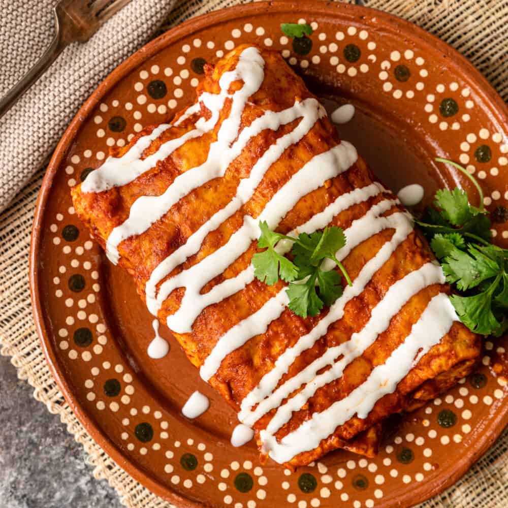 red enchiladas with crema drizzled on top