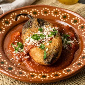 crispy chili relleno in red sauce on plate