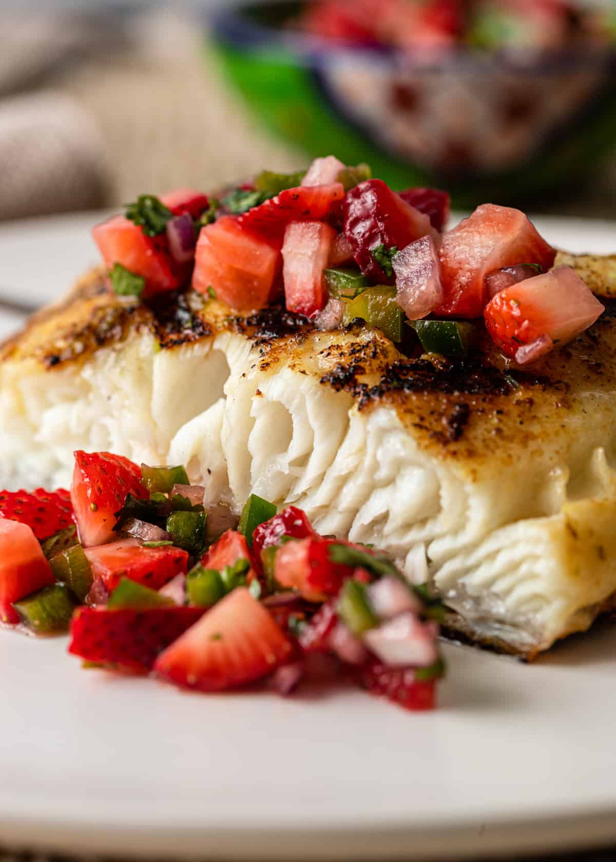 flaky Grilled Sea Bass on a plate with strawberry salsa