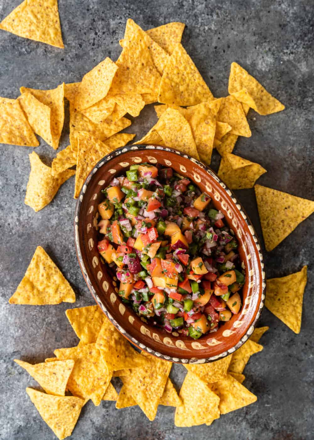 overhead view of peach salsa in bowl in chips