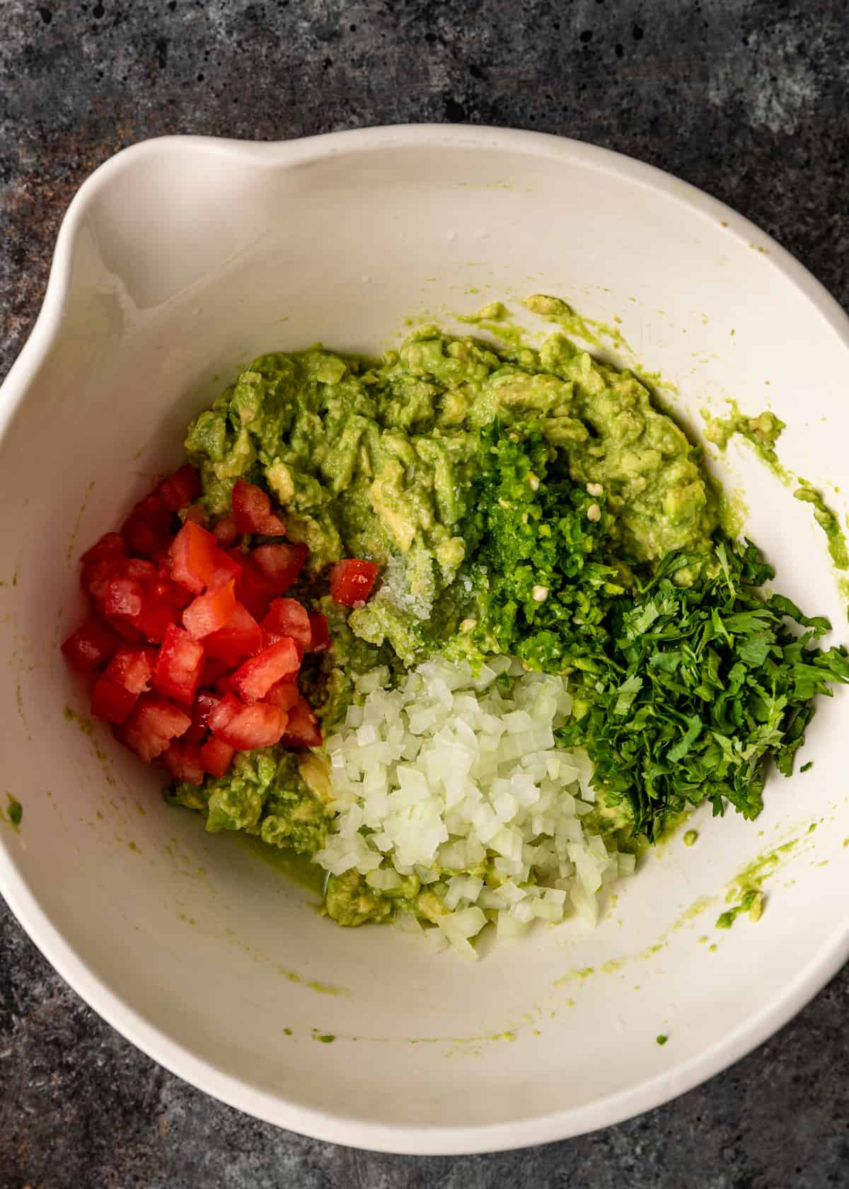 mixing guacamole ingredients together in a bowl