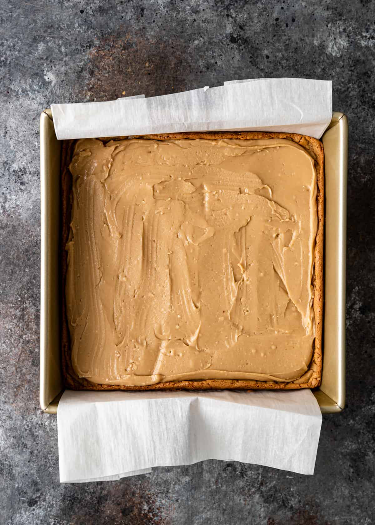 adding frosting to Butterscotch Blondies