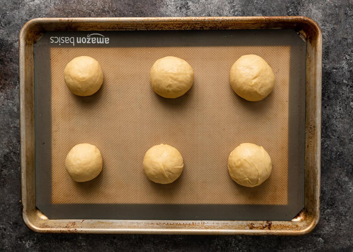 6 conchas dough balls on a baking sheet